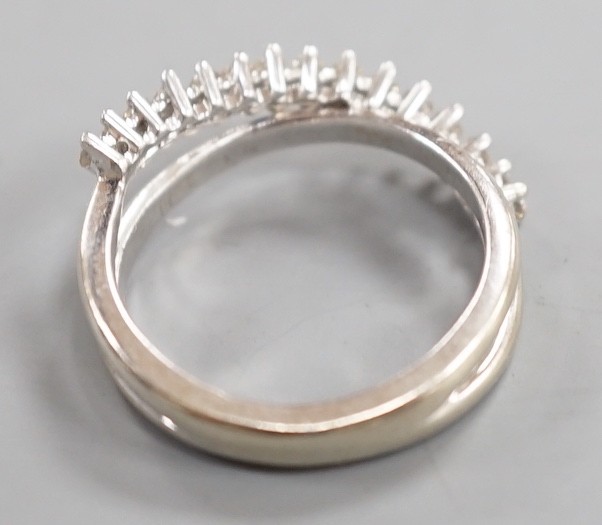 A modern 18ct white gold and diamond chip set half hoop crossover ring, size O, gross weight 3.9 grams.